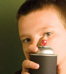 This is a photograph of a boy spraying an aerosol ca