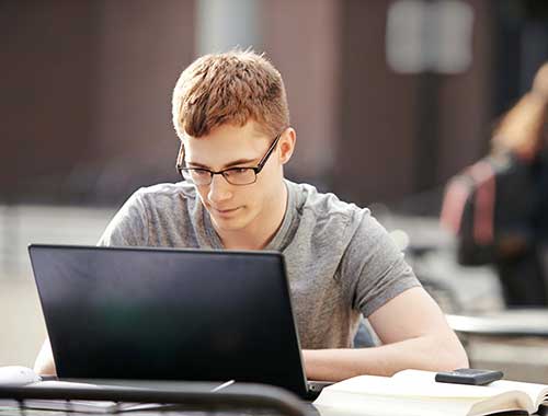 Teen boy working on his laptop.