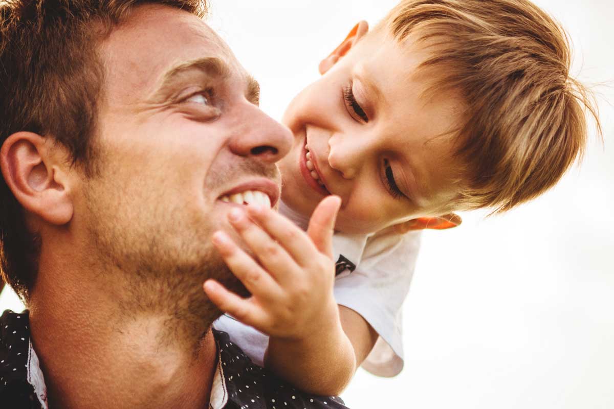 Man with young boy on shoulders.