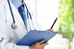 Doctor sosteniendo una carpeta.