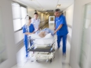 Doctors pushing stretcher down hallway