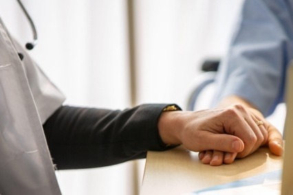 Primer plano de un médico sosteniendo la mano de un paciente
