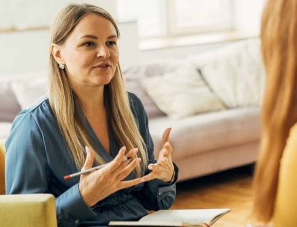 Two women in armchairs are sitting and talking.