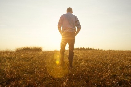 Silueta de un hombre caminando en el campo al atardecer