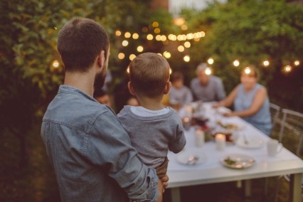 Familia multigeneracional cenando en el patio trasero de su casa.