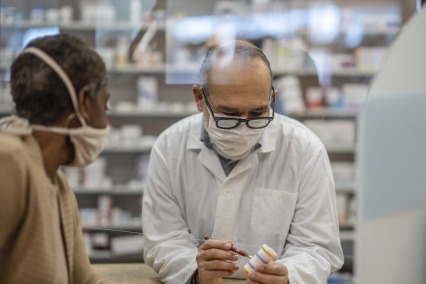 Medical practitioner discussing prescription medication with a customer.