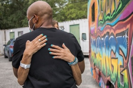 Dr. Hansel Tookes embraces IDEA participant Melissa.