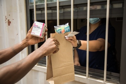 Syringe services program staff member distributing harm reduction supplies.