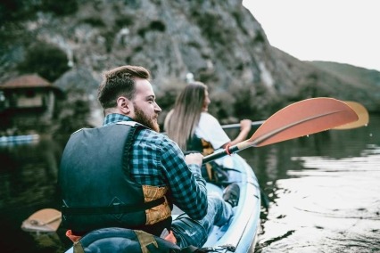 Adult couple kayaking on a lake together