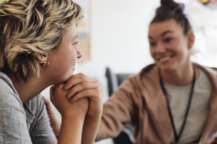 Side view of female health professional talking with a teenager.