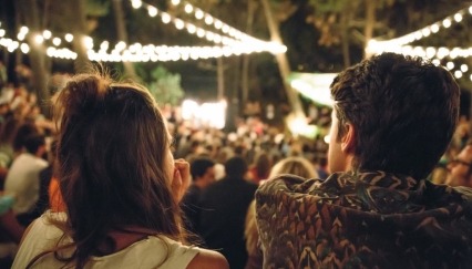 Rear view of young couple enjoying an outdoor festival at night