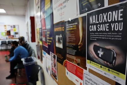Close-up of naloxone poster hanging on the wall of a health clinic.