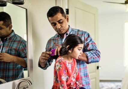 Father brushing young daughter's hair.