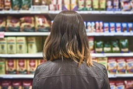 Rearview shot of a young woman shopping at a grocery store.