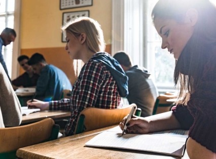 Teenage students sitting in the classroom taking an exam.