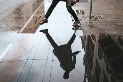 Reflejo de hombre saltando sobre un charco