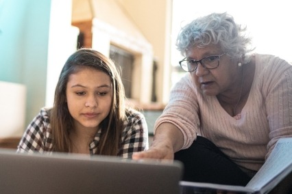 Grandmother helping granddaughter with homework.