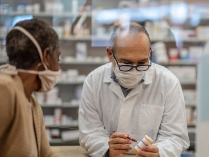 Pharmacist discussing prescription medication with a customer.