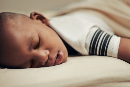 Young boy sleeping in bed.