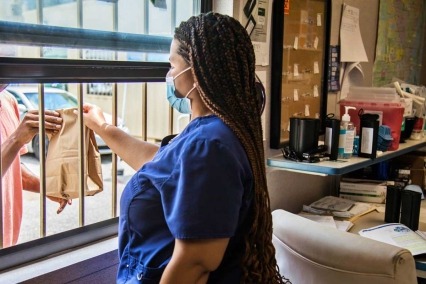 Syringe services program staff member distributing harm reduction supplies.