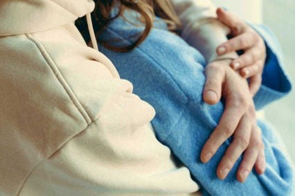 Primer plano de una pareja de adultos abrazada.