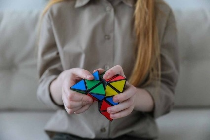Close-up of child’s hands playing with a Rubik’s cube