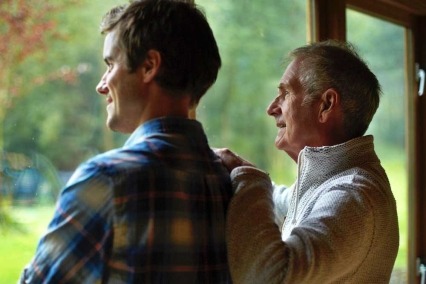Father and son looking out a window