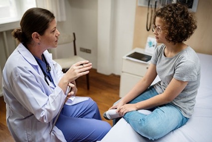 A female doctor talking to a young girl