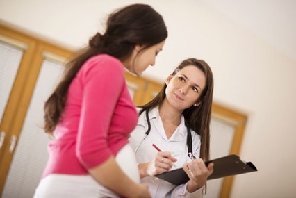 A young woman talking to a female doctor