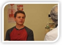 An adolescent boy talking to a doctor