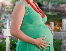 Pregnant Native American woman in summer garden