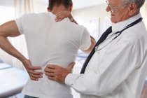 ale Doctor and patient suffering from back pain during medical exam