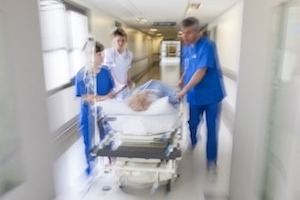 Doctors pushing stretcher down hallway