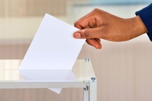 Hand dropping paper in slot of suggestion box