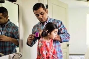 Father brushing young daughter's hair.
