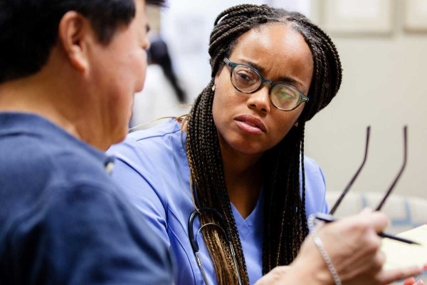 Emergency room clinician talking with patient.