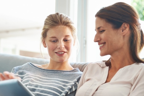 Mother and teen girl viewing online resources together.