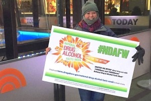 A NIDA employee holding a NDAFW sign at the Today Show plaza