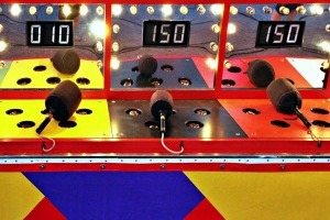 Close-up of a brightly lit whack-a-mole carnival game.