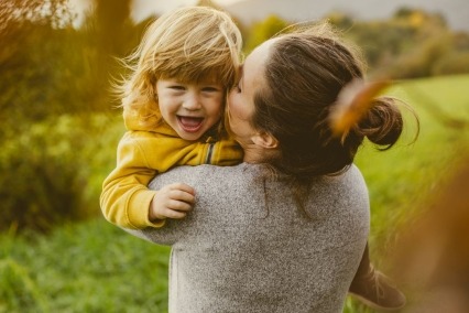 Woman holding young child in her arms