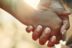 Close-up of two people holding hands. Primer plano de las manos de dos personas unidas.