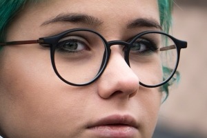 Close-up of young woman wearing glasses.